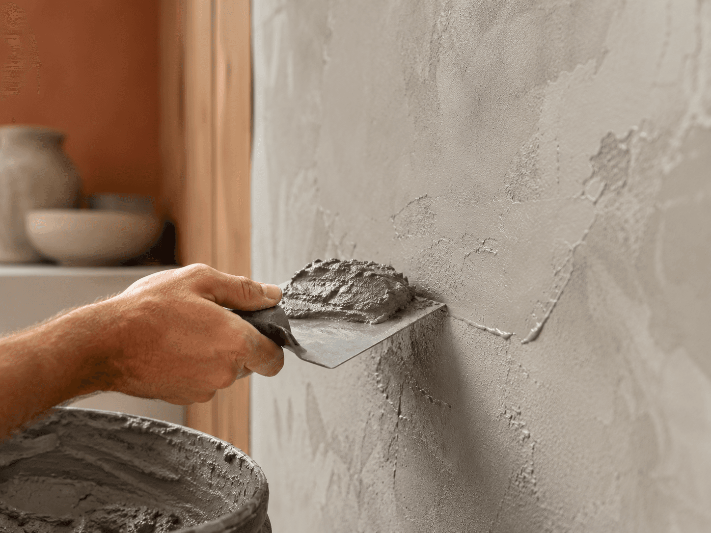 Loading microcement onto a steel trowel to apply to a wall